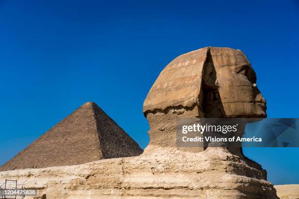 Sphinx with view of the Great Pyramids of Giza, Cairo, Egypt.