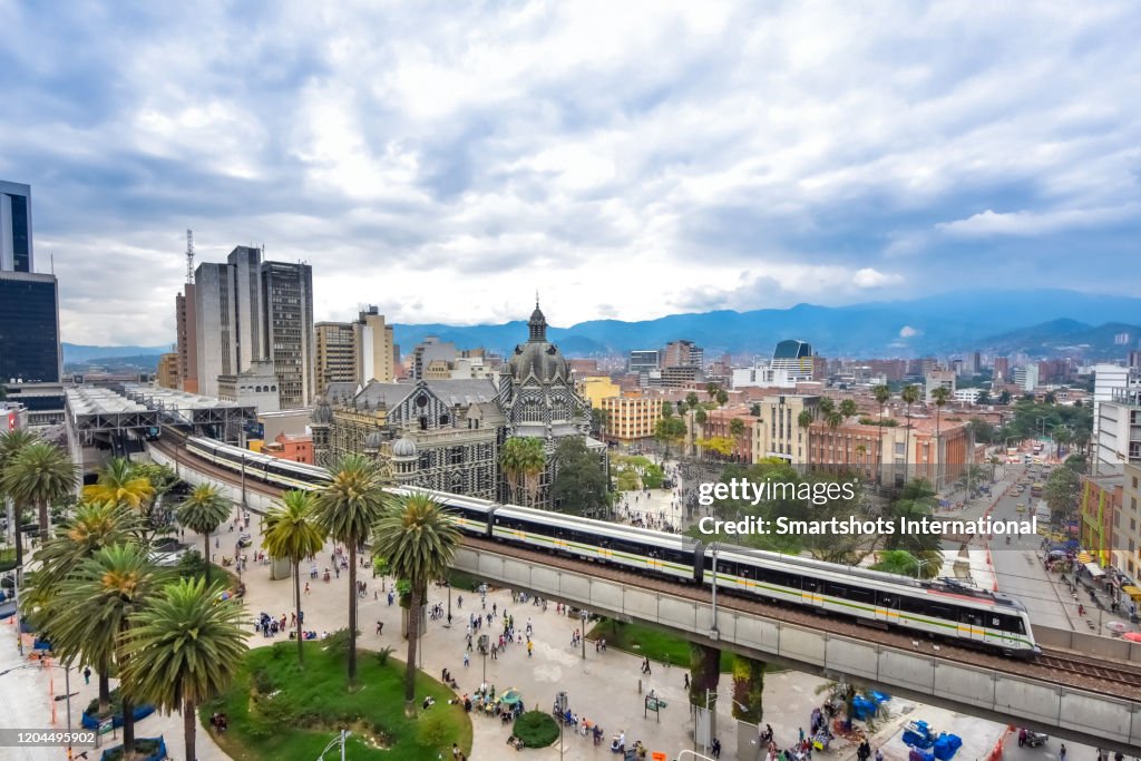 High angle view of Medellin cityscape with elevated metro train on foreground in Antioquia, Colombia