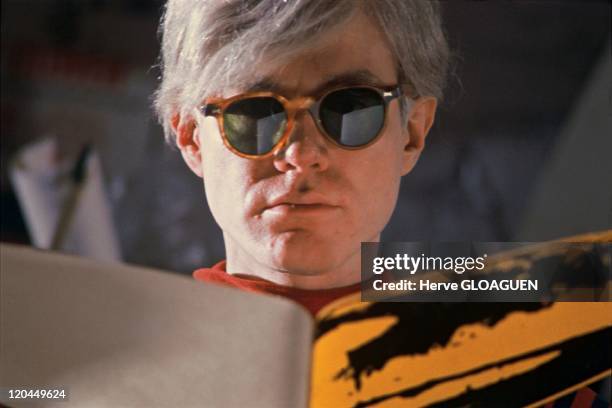 Andy Warhol in New York, United States in 1966 - Andy Warhol at the Factory, he tears a huge banana plastic before fixing it on the paper.