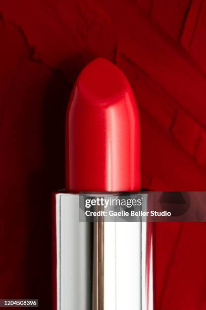 fashionable new red lipstick on dark red smudged lipstick background - 赤の口紅 ストックフォトと画像