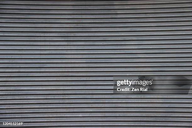 commercial roll-up metal door of a store - grooved stock-fotos und bilder