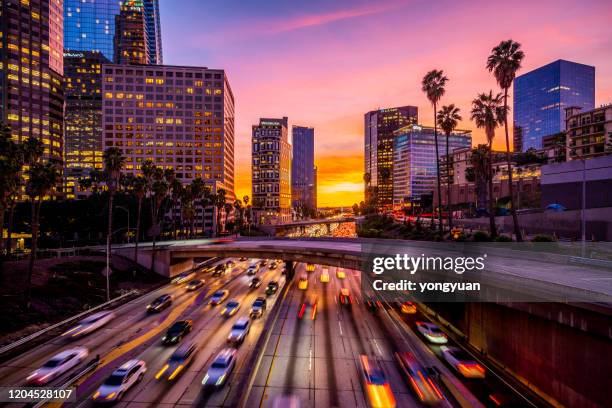 busy traffic in downtown los angeles at sunset - los angeles cityscape stock pictures, royalty-free photos & images