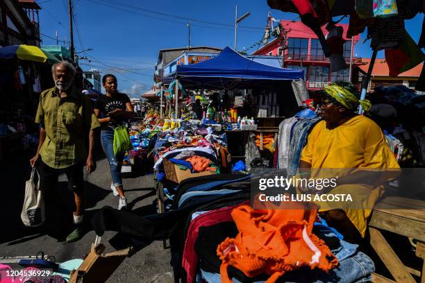 People walk through Stabroek Market in Georgetown, Guyana, on March 1, 2020. - Guyana goes to the polls March 2 in a pivotal election in one of South...