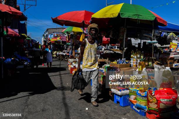 People walk through Stabroek Market in Georgetown, Guyana, on March 1, 2020. - Guyana goes to the polls March 2 in a pivotal election in one of South...