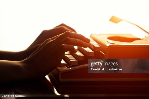 close up shot of woman typing on old vintage retro typewriter. - story telling in the workplace stockfoto's en -beelden