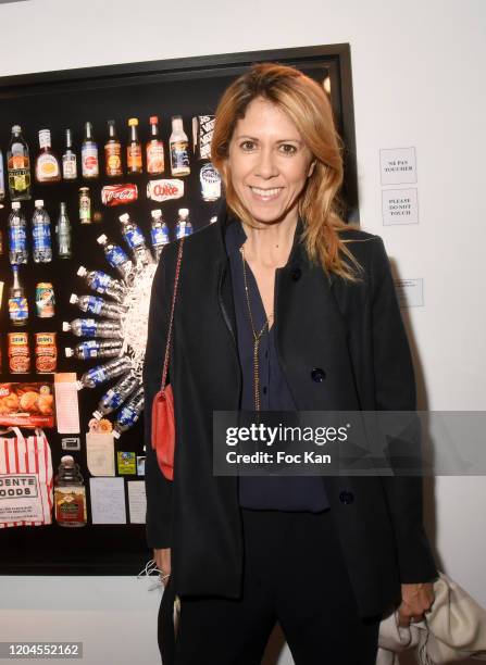 Presenter Rachel Bourlier poses with a picture of John Travolta’s dustbin contents during "Paparazzi" Bruno Mouron et Pascal Rostain Exhibition...