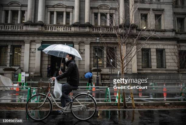 Man, wearing a face mask, cycles past the Bank of Japan in Tokyo's financial district on March 2, 2020 in Tokyo, Japan. Prime Minister Shinzo Abe...