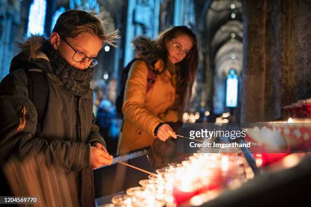 hermano y hermana orando en la iglesia candelabrum - innocence fotografías e imágenes de stock