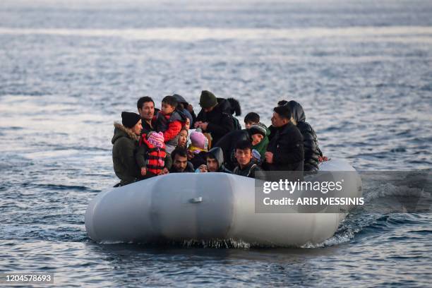 Refugees and migrants aboard an inflatable boat arrive in the Greek island of Lesbos on March 2, 2020. - Around 500 migrants landed on Sunday morning...