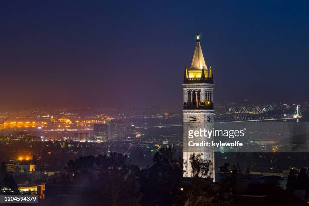 uc berkeley campanile clock tower and bay bridge at dusk, berkeley, california, usa - college campus aerial stock pictures, royalty-free photos & images