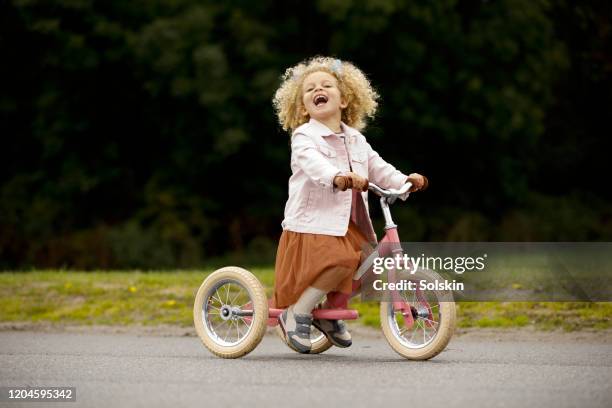 girl riding tricycle - tricycle stock pictures, royalty-free photos & images