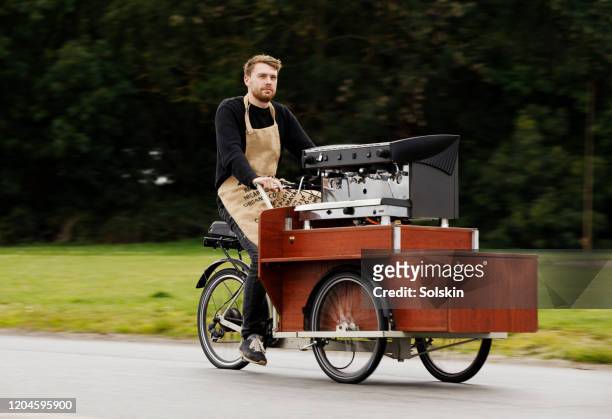 young man on bicycle coffee shop - coffee bike stock pictures, royalty-free photos & images