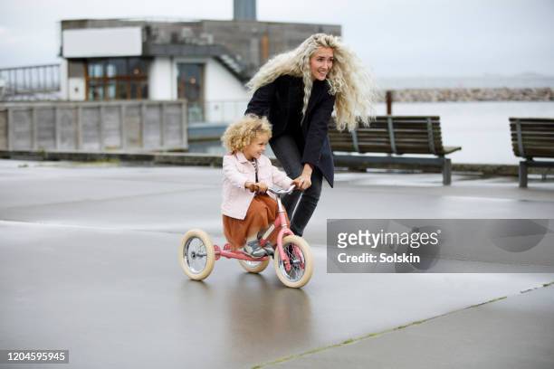 Mother teaching daughter to bicycle