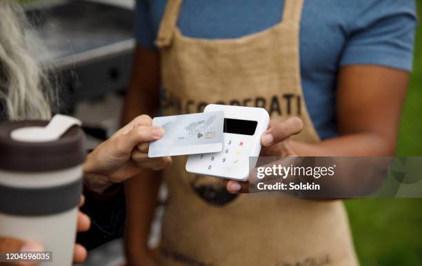 customer paying for coffee at bicycle coffee shop - kontaktlos bezahlen stock-fotos und bilder