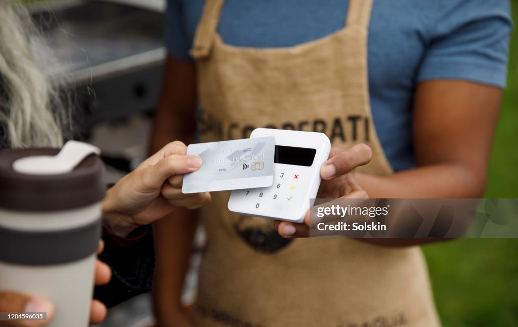 Customer paying for coffee at bicycle coffee shop