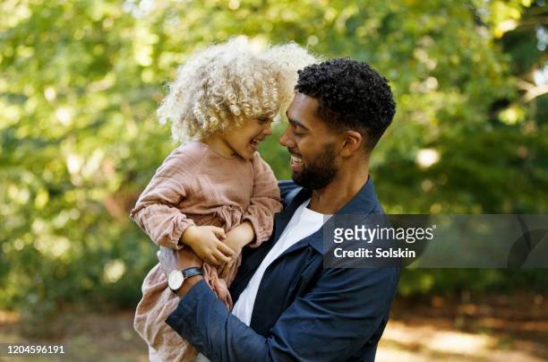 father and daughter in park, having fun together - person gemischter abstammung stock-fotos und bilder