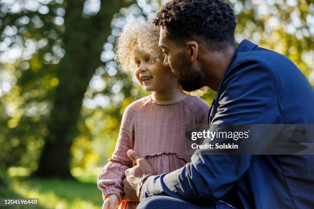 father and young daughter in park area - foreign born stock pictures, royalty-free photos & images