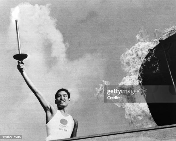 Picture taken on October 10, 1964 at Tokyo showing Japanese Olympic torch runner Yoshinori Sakai from Hiroshima after lighting the Olympic torch...