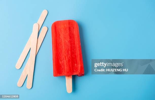 red ice lolly and sticks on blue background - wooden stick stock pictures, royalty-free photos & images