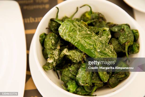 padron peppers served in a bowl - pimientos stockfoto's en -beelden