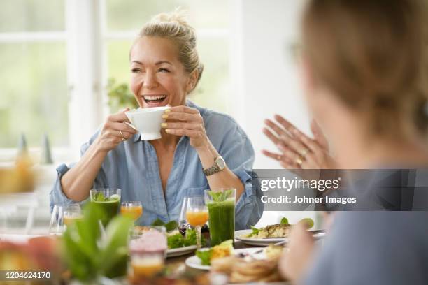 happy woman at table - mature women eating stock pictures, royalty-free photos & images