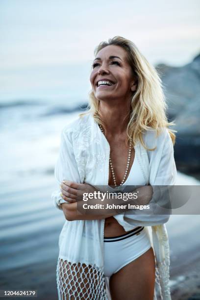 happy woman on beach - middle age woman in bathing suit stock pictures, royalty-free photos & images