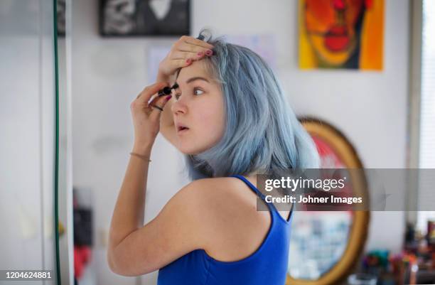 young woman doing make-up - girl in mirror stockfoto's en -beelden