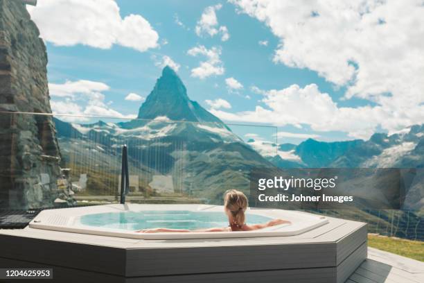 woman in hot tub looking at mountains - luxury spa stock pictures, royalty-free photos & images