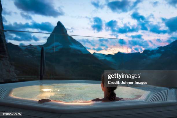 woman in hot tub looking at mountains - luxury spa stock pictures, royalty-free photos & images