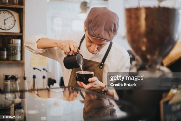 's ochtends maken barista-mannen het warme lattemenu voor de klant in het café. - barista stockfoto's en -beelden