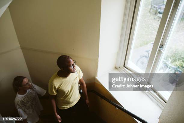 couple looking through window - house warming stock pictures, royalty-free photos & images