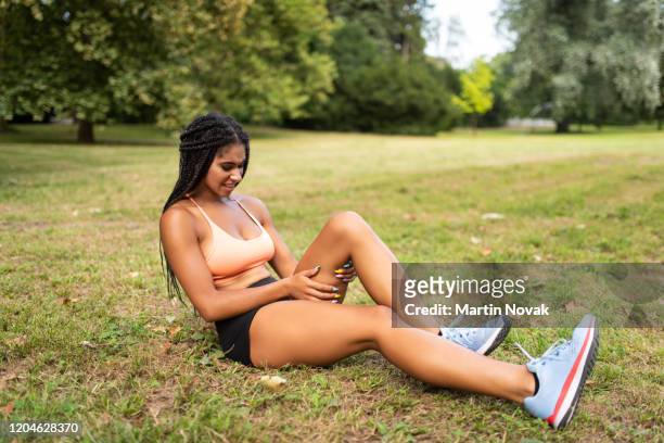 ruptured thigh muscles making woman athlete uncomfortable - sportlerin stock-fotos und bilder