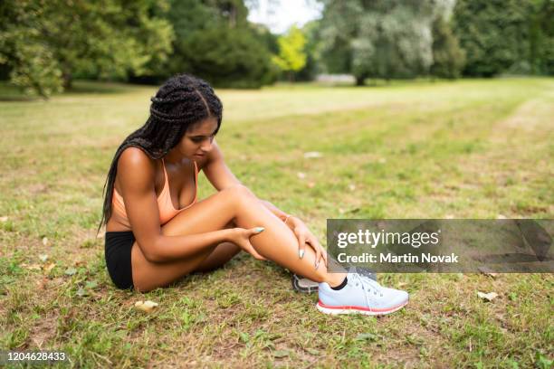 sportswoman suffering from leg injury due to muscle rupture - female muscular calves fotografías e imágenes de stock