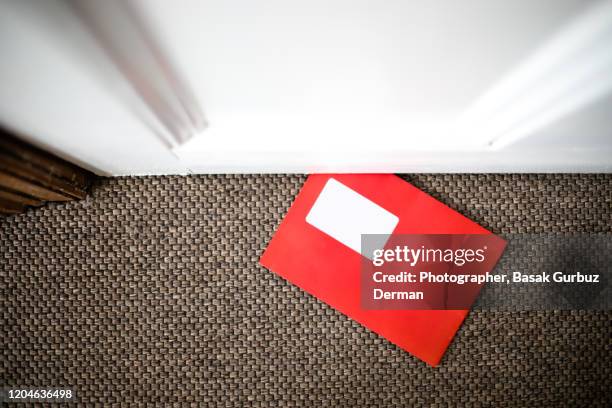 red envelope / mail under the door on the floor - debajo de fotografías e imágenes de stock