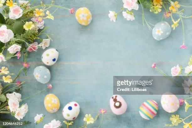 easter eggs and flowers on a rustic blue wood background - easter stock pictures, royalty-free photos & images