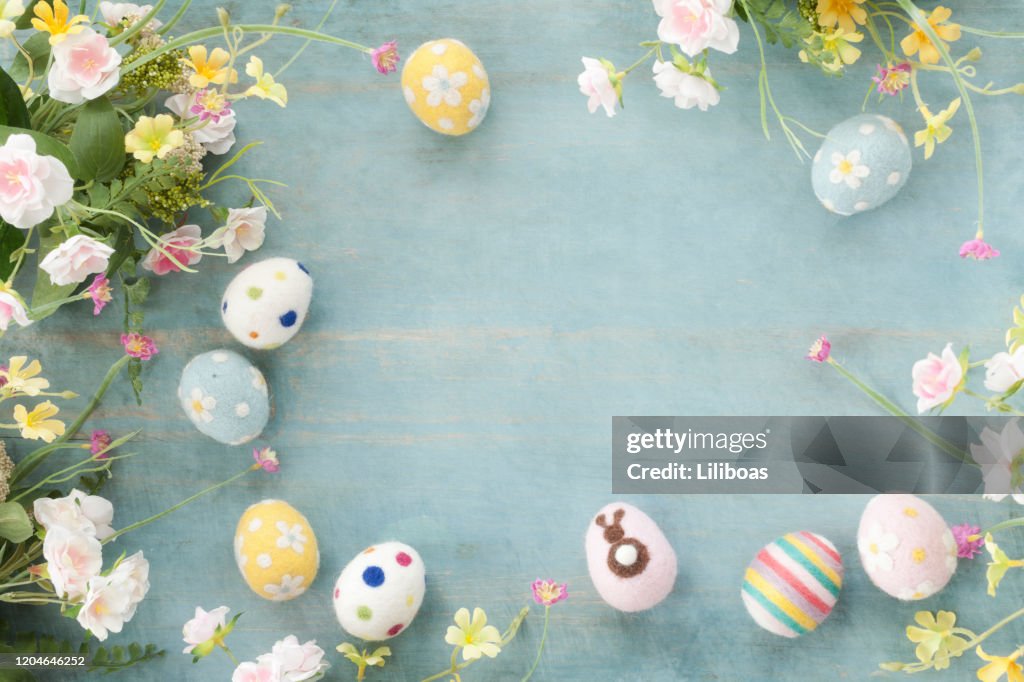 Ovos de Páscoa e Flores em um fundo rústico de madeira azul