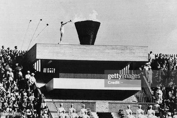 Picture taken on October 10, 1964 at Tokyo showing Japanese Olympic torch runner Yoshimori Sakai from Hiroshima lighting the Olympic torch during the...