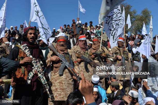 Afghan Taliban militants and villagers attend a gathering as they celebrate the peace deal and their victory in the Afghan conflict on US in...
