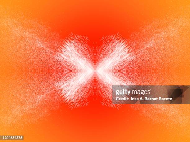 full frame of the textures formed  by the water jets to pressure with drops floating in the air of color white on a orange background - explosives stockfoto's en -beelden