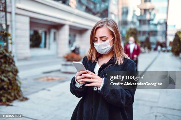 vrouw die haar weg vindt op gps terwijl het dragen van anti air pollution mask - air pollution mask stockfoto's en -beelden