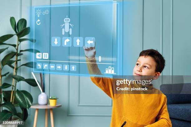 futuristic child programming robot on virtual screen. - kids programming home stock pictures, royalty-free photos & images