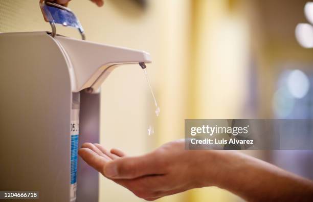 nurse cleaning hands with antiseptic fluid - disinfection stock-fotos und bilder