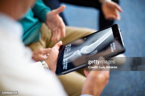 doctor explaining x-ray report to patient - medisch dossier stockfoto's en -beelden