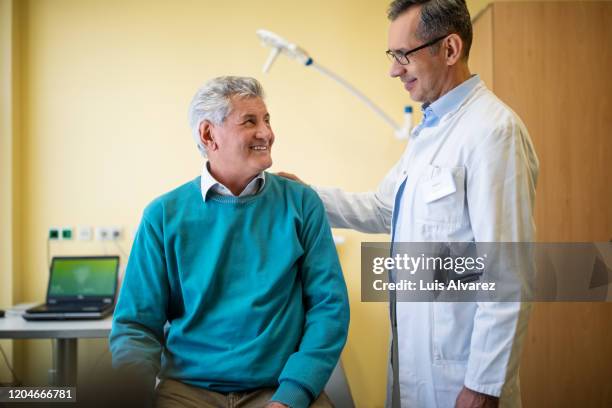 happy senior male patient at clinic for checkup - man talking to doctor bildbanksfoton och bilder