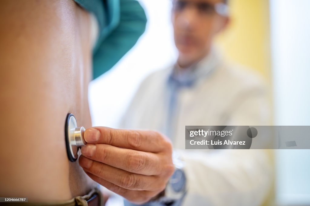 Doctor examining patient with stethoscope