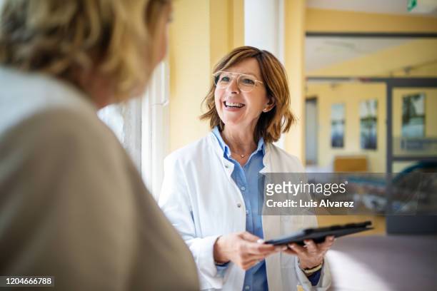 doctor discussing with woman at nursing home - messa a fuoco differenziale foto e immagini stock