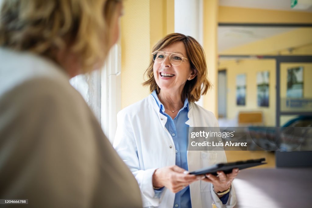 Doctor discussing with woman at nursing home