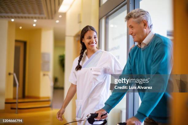 nurse helping man with walking frame - 老年医学 ストックフォトと画像