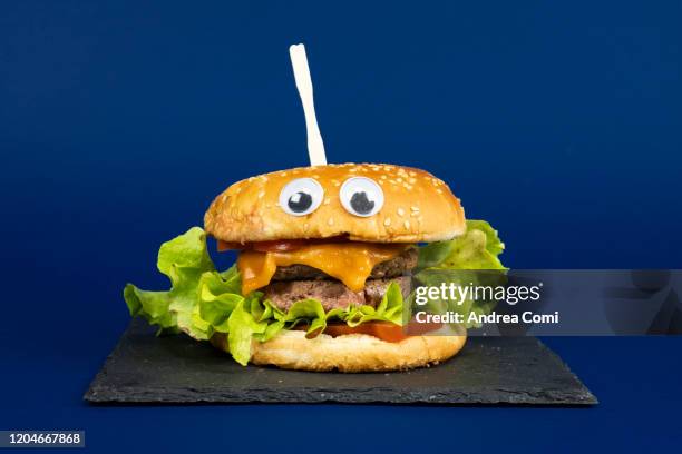 cheeseburger with googly eyes - nobody burger colour image not illustration stock pictures, royalty-free photos & images