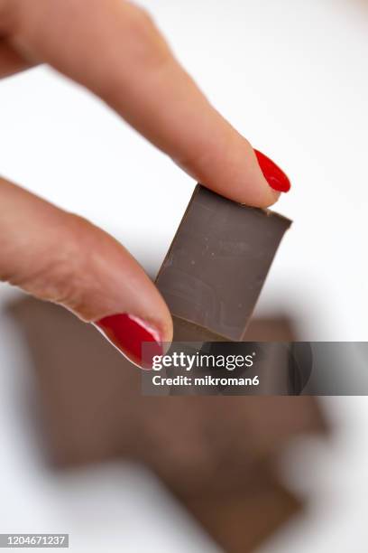 woman holding chocolate chunks - eating dark chocolate stock pictures, royalty-free photos & images